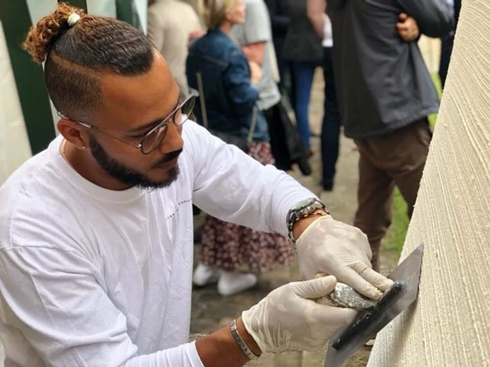 Pascal Pereira, fondateur de PEREINOV, applique un enduit décoratif à la truelle devant un public