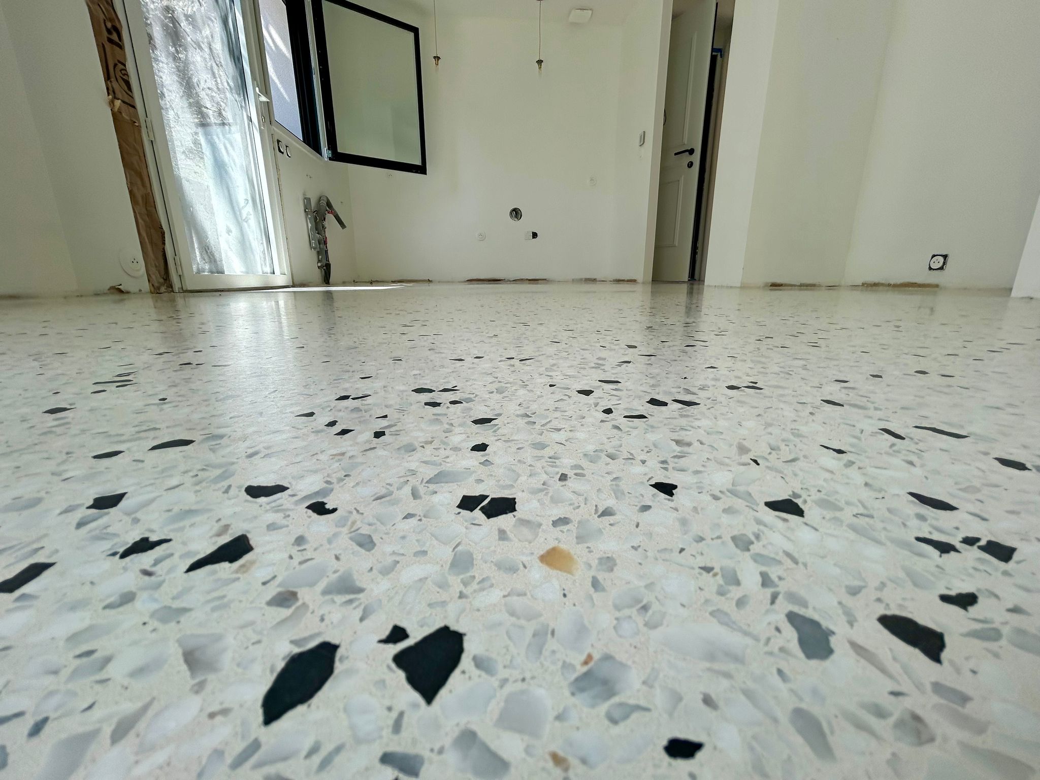 Détail d'un sol terrazzo poli montrant les éclats de marbre et de granit